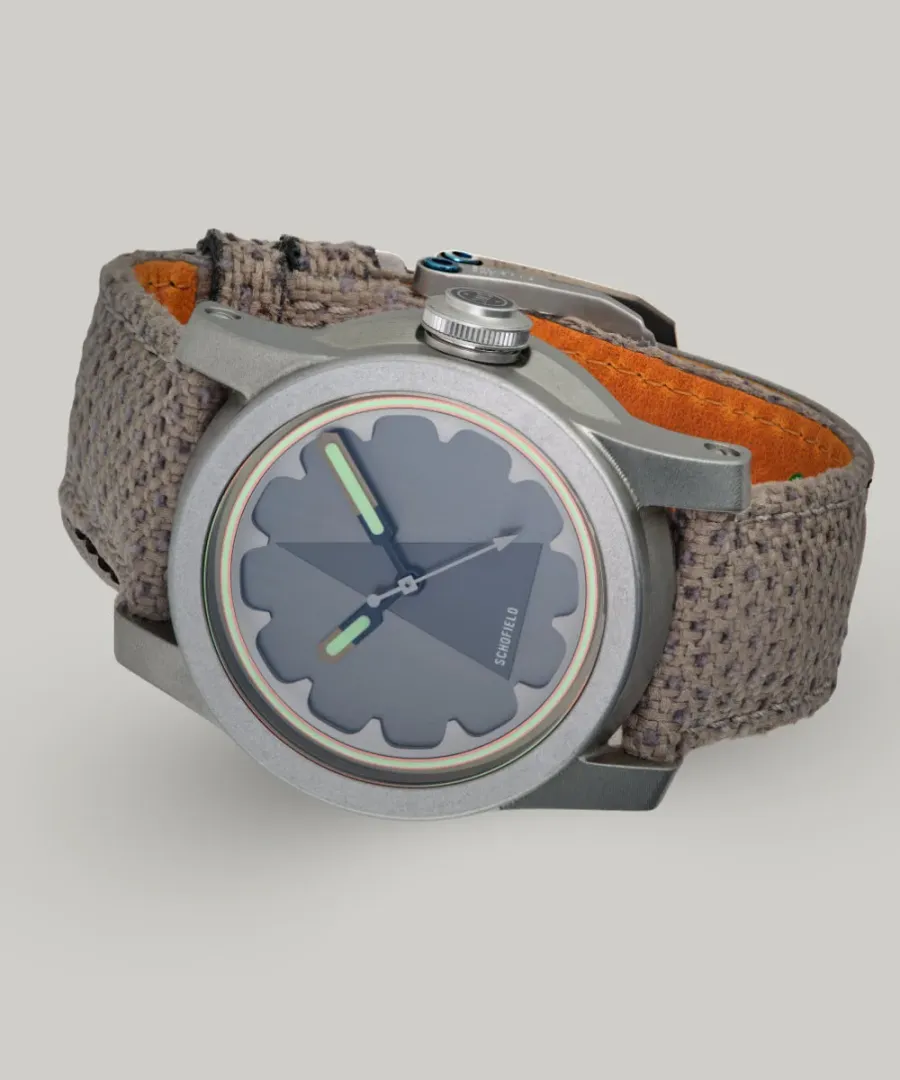 Schofield Skeptiko Sightings in tumbled steel with a grey triangle dial on a grey chenille strap