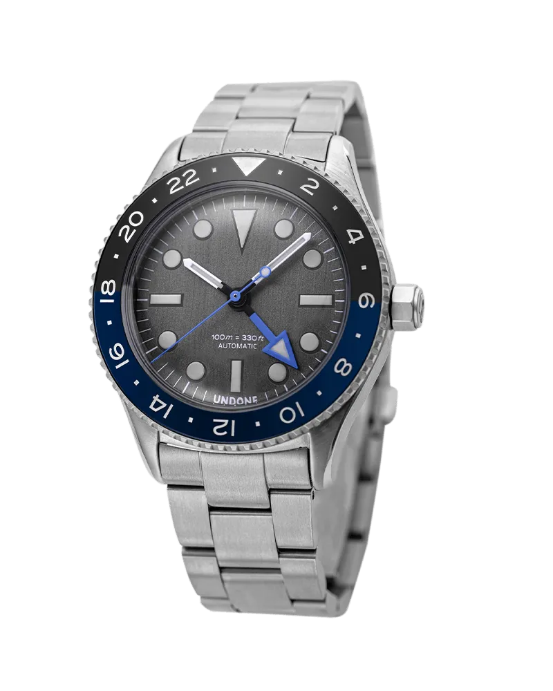Undone Basecamp Titanium GMT Collector with grey dial, blue GMT hand and black and blue 24-hour bezel on a titanium bracelet