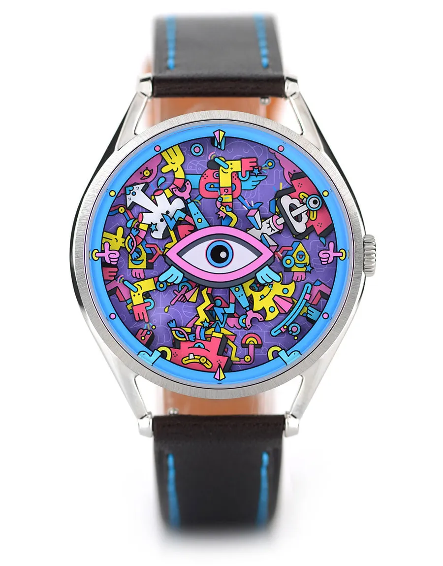 Mr Jones Khaosify Mechanical, crowded cartoon-character dial around a central eye, 40mm steel case on dark brown leather with blue stitching, front view