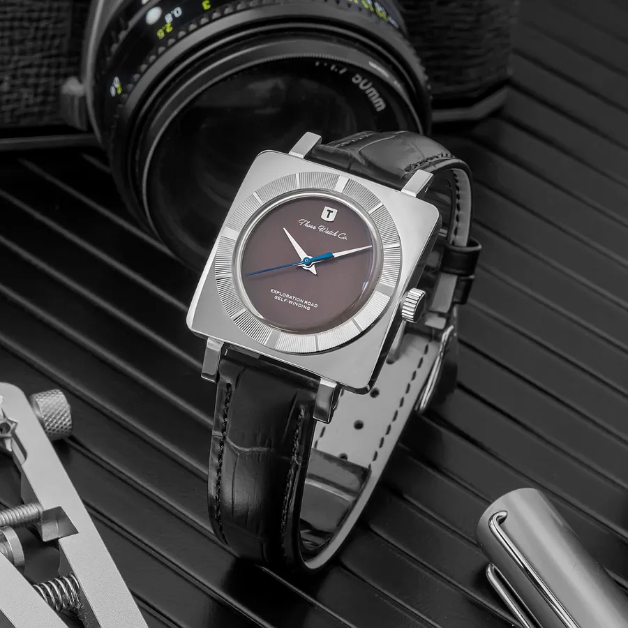 Thorn T016 square-cased watch with dark grey dial and blue seconds hand on a black leather strap