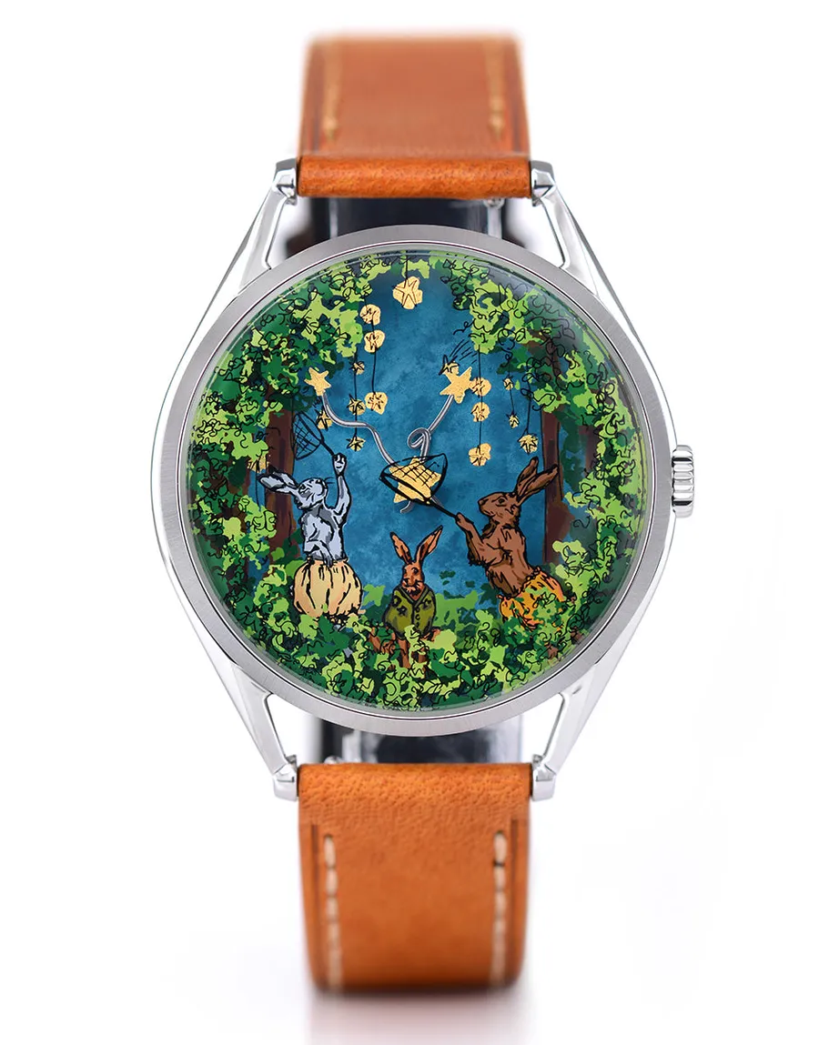 Mr Jones Starcatcher, three hares catching gold-leaf stars in a celestial woodland, steel case on tan leather, front view