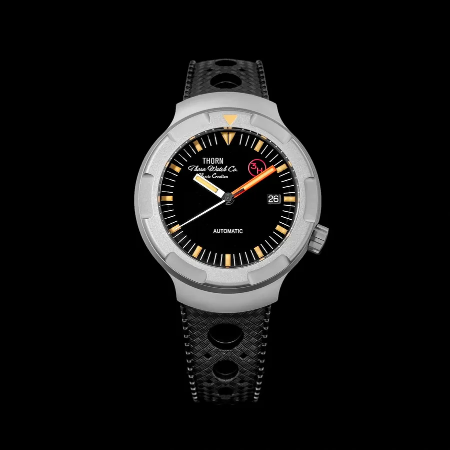 Thorn T011 titanium diver with black dial, orange accents and date at 3 on a perforated rubber strap