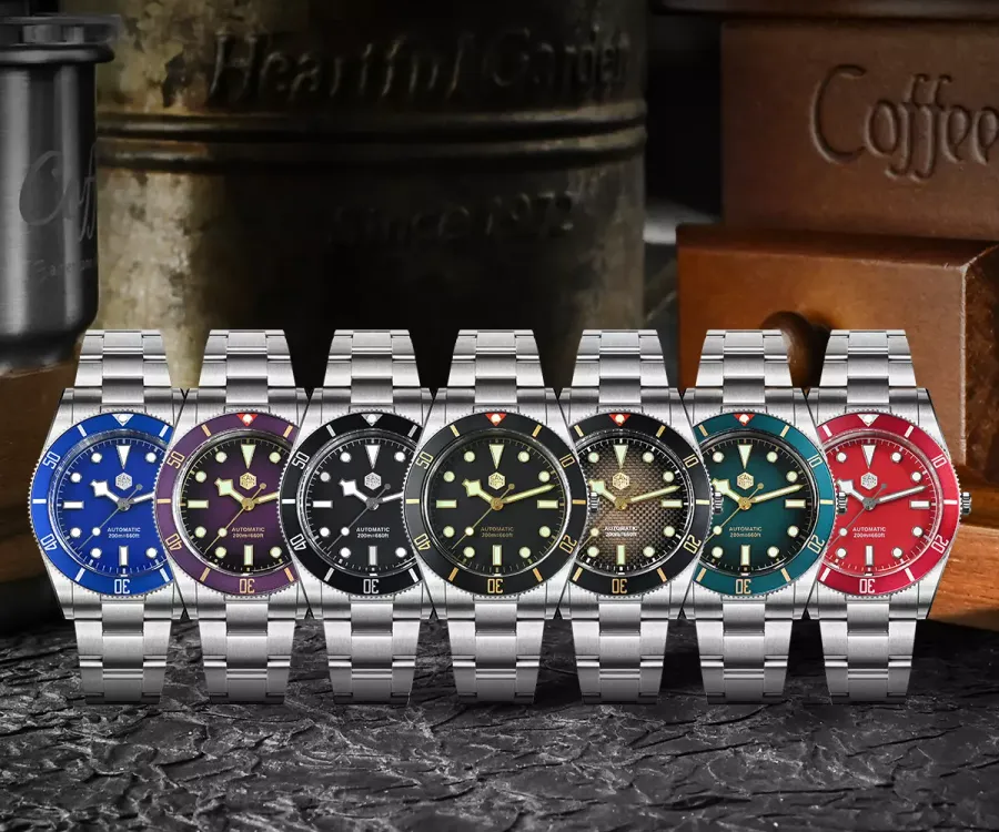 Seven San Martin SN0138-B divers with blue, purple, black (two), gradient brown, green and red dials and matching aluminium bezels on three-link bracelets
