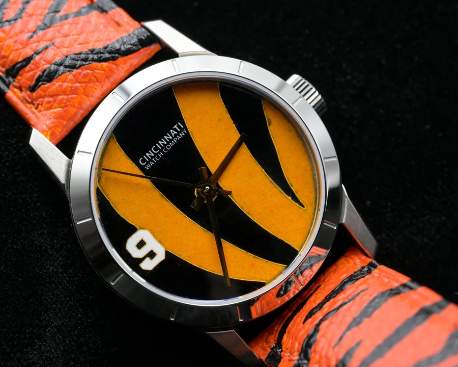 Cincinnati Watch Company Stripes (2026), cloisonné enamel orange and black tiger stripes with a white 9, on a hand-painted tiger-stripe leather strap