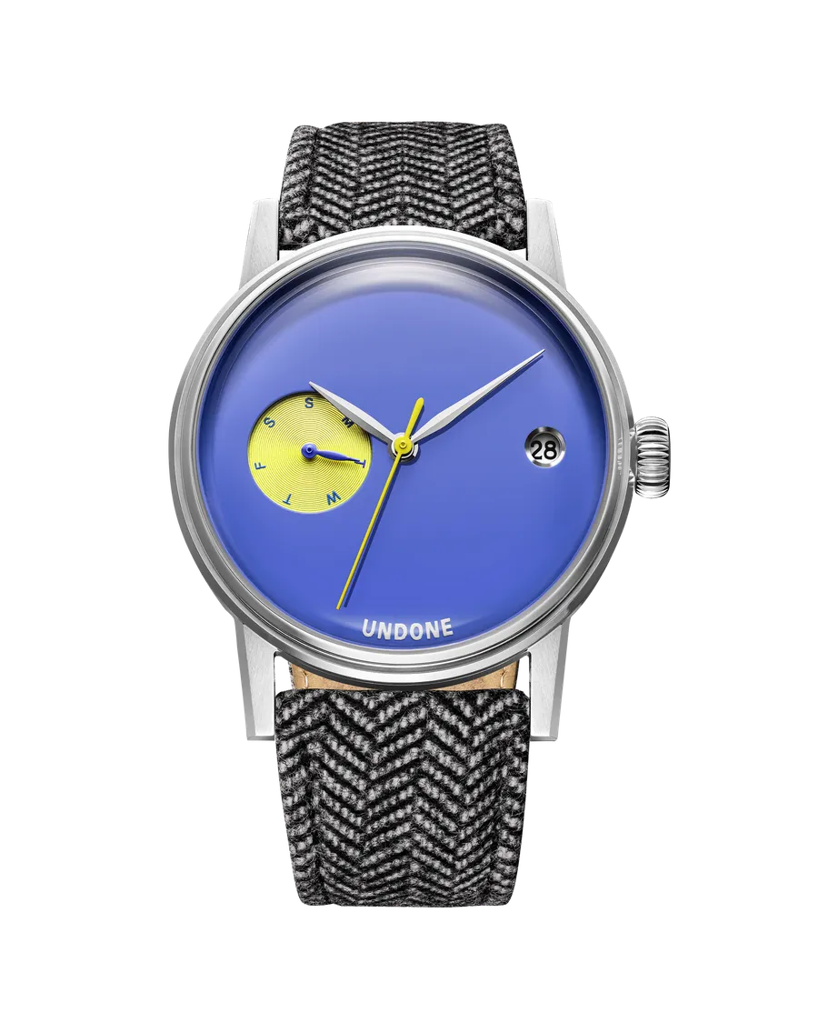 Undone Urban 37 Orson with deep blue enamel dial, yellow day subdial at 9 and date at 3 on a grey fabric strap