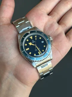 Thorn T023 V3.1 with blue dial, date at 3 and blue bezel, held in the hand