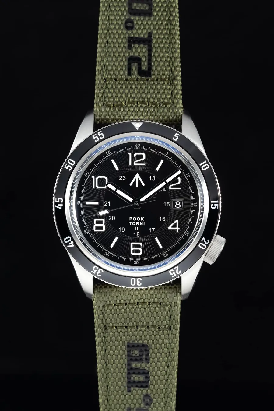 Pook Torni II with black dial, large Arabic numerals, date at 3 and black 60-minute bezel on a green braided nylon strap