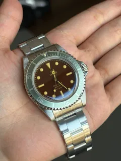 Thorn T023 V3.1 with brown dial and faded bezel, held in the hand