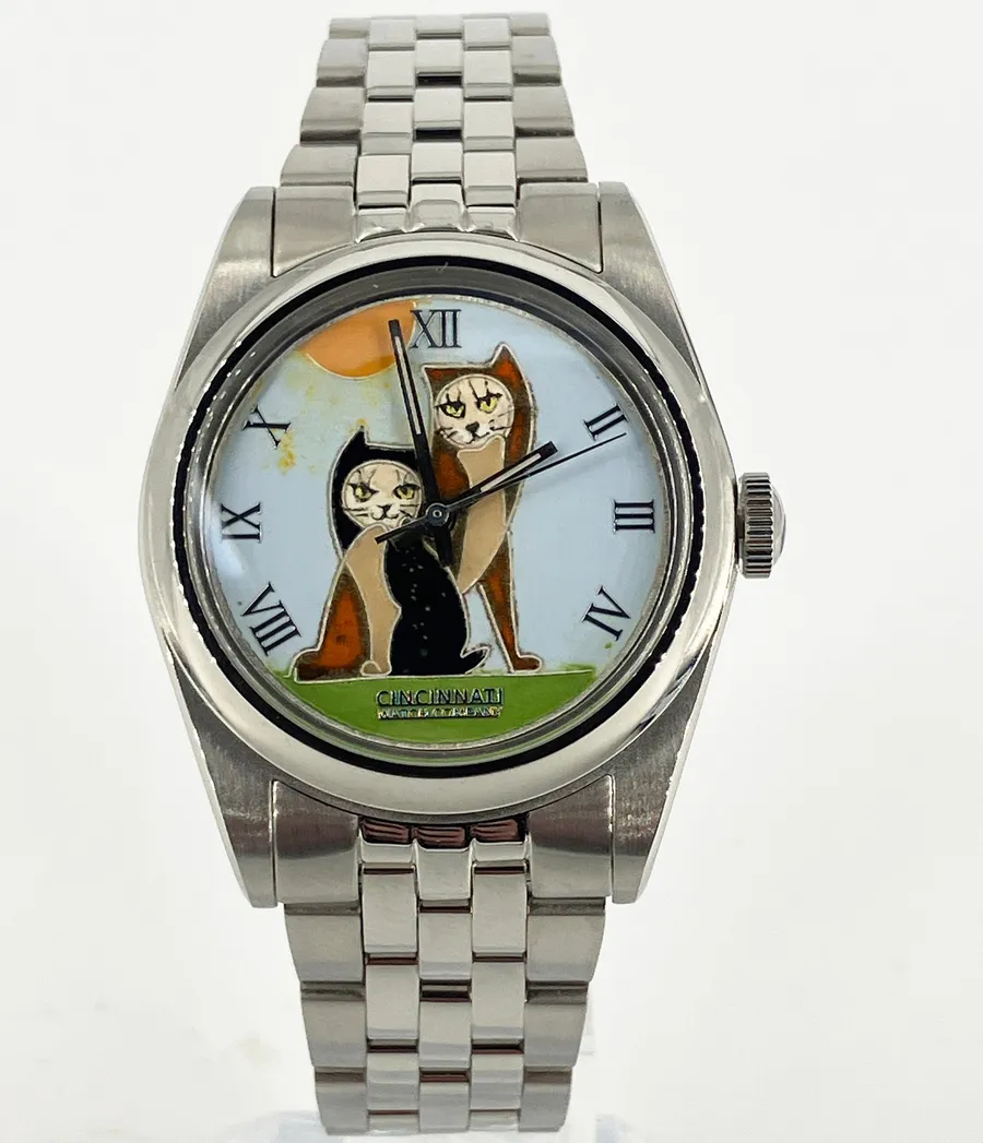 Cincinnati Watch Company Two Cats in Front of the Sun, enamel black and tan cats before an orange sun on a pale blue dial with Roman numerals, on a five-link bracelet