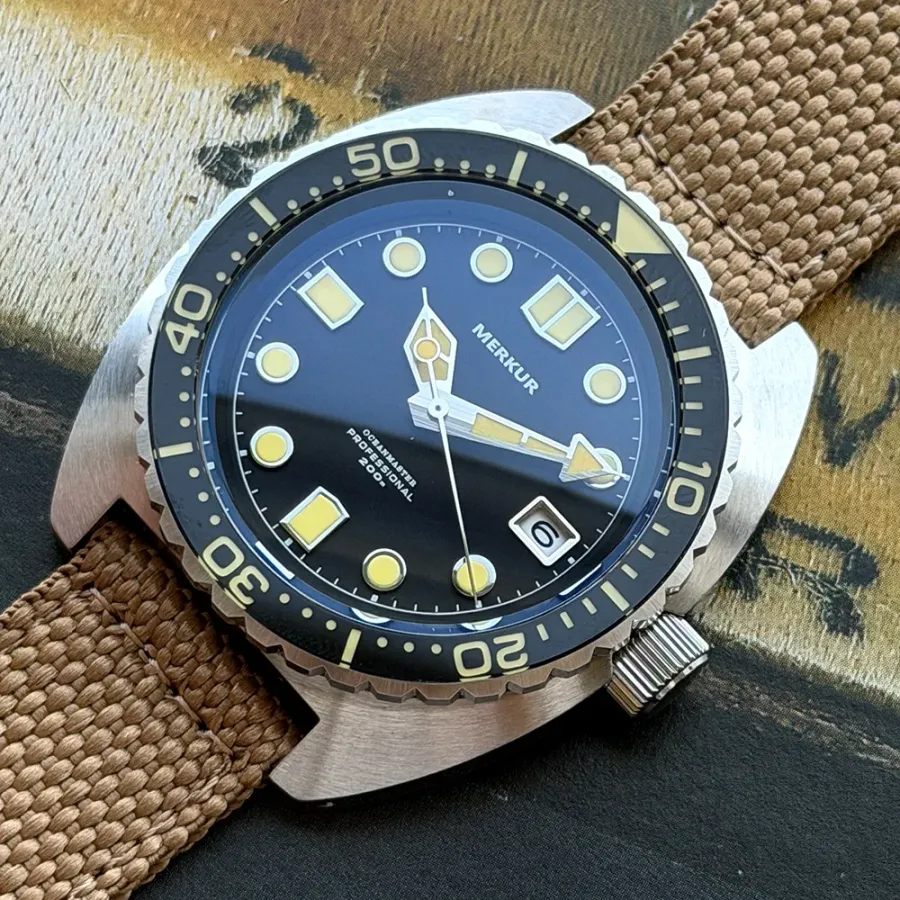 Merkur 6105-style skin diver with black dial and black bezel on tan canvas strap